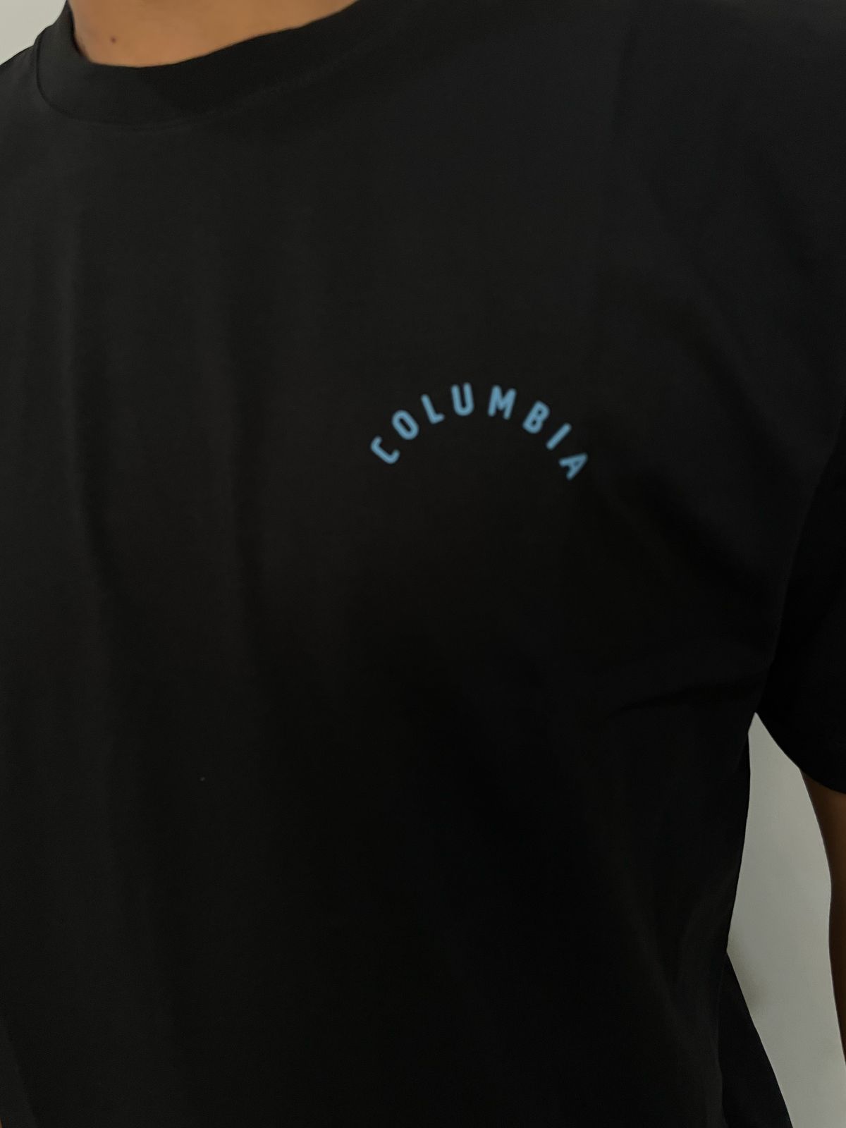 Polo Columbia negro / logo celeste pequeño